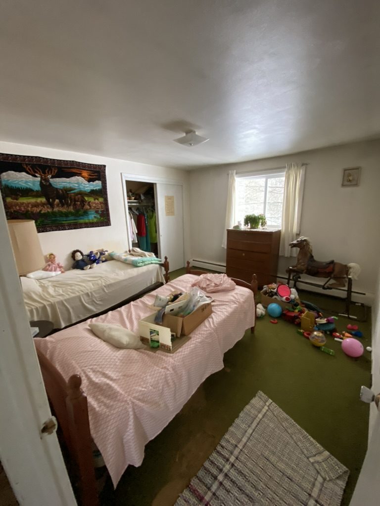 A cluttered bedroom before a Clear The Clutter cleanout.