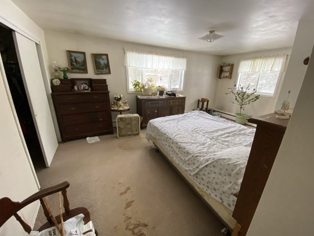 Bedroom with a bed, dresser, chair, and household items