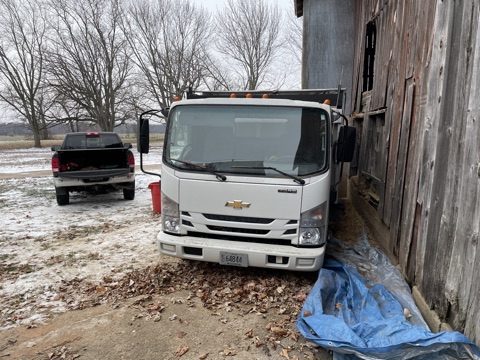 Clear The Clutter truck parked near a barn and outbuilding.