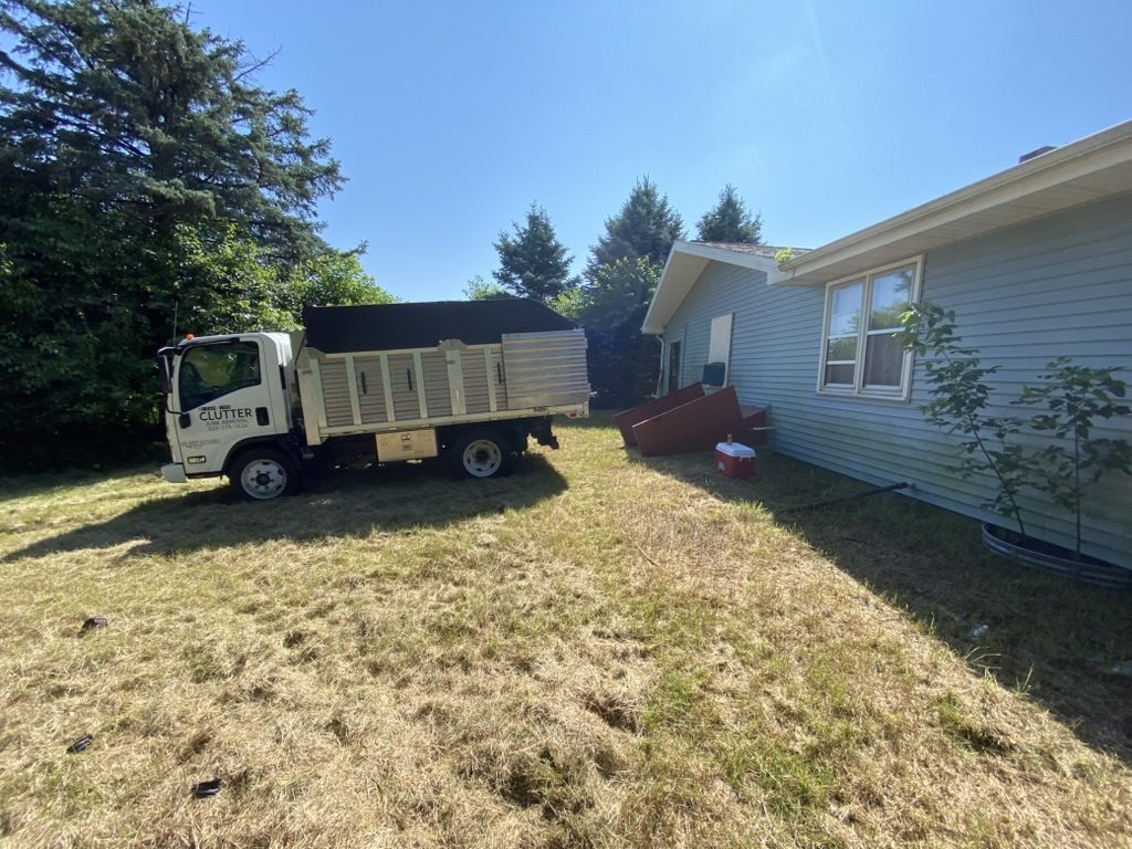 Clear The Clutter truck parked beside a house