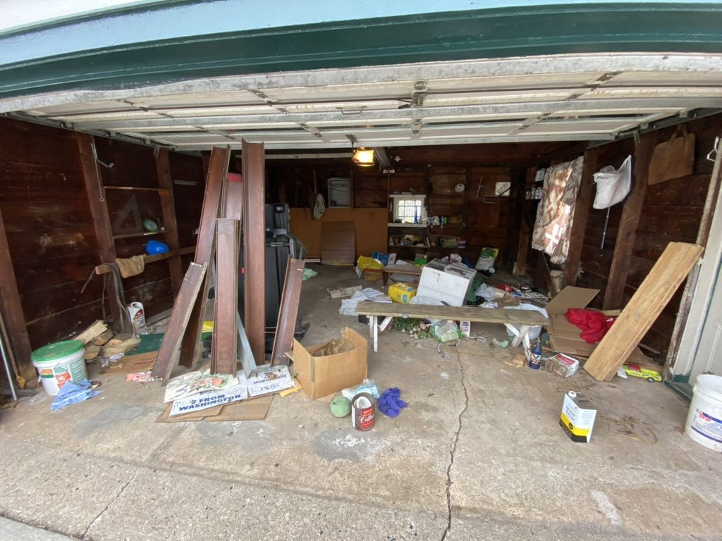 Garage containing tools, lumber, containers, and stored items