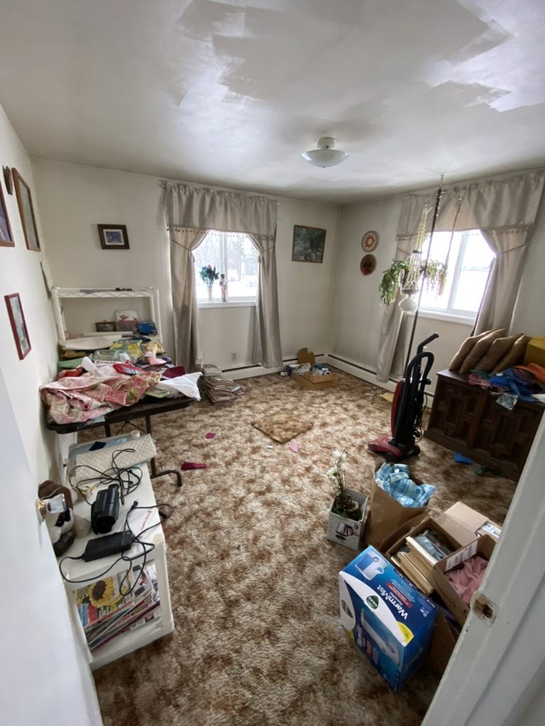 Living room containing furniture, boxes, and household items