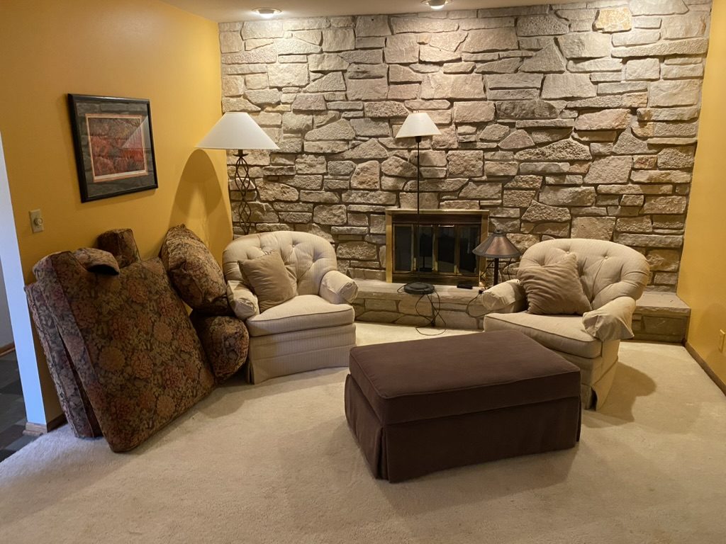 Living room with seating and a stone fireplace