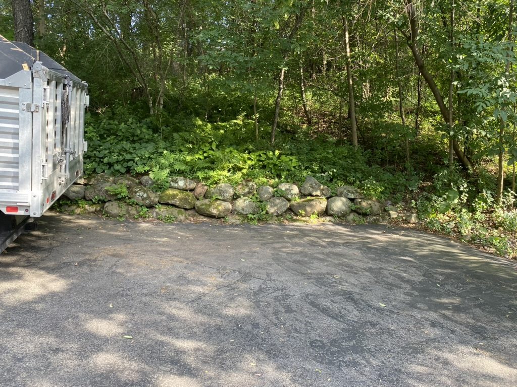 Clear The Clutter truck parked along a wooded driveway.